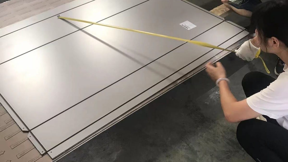 Technician checking ACP fabrication dimensions before processing