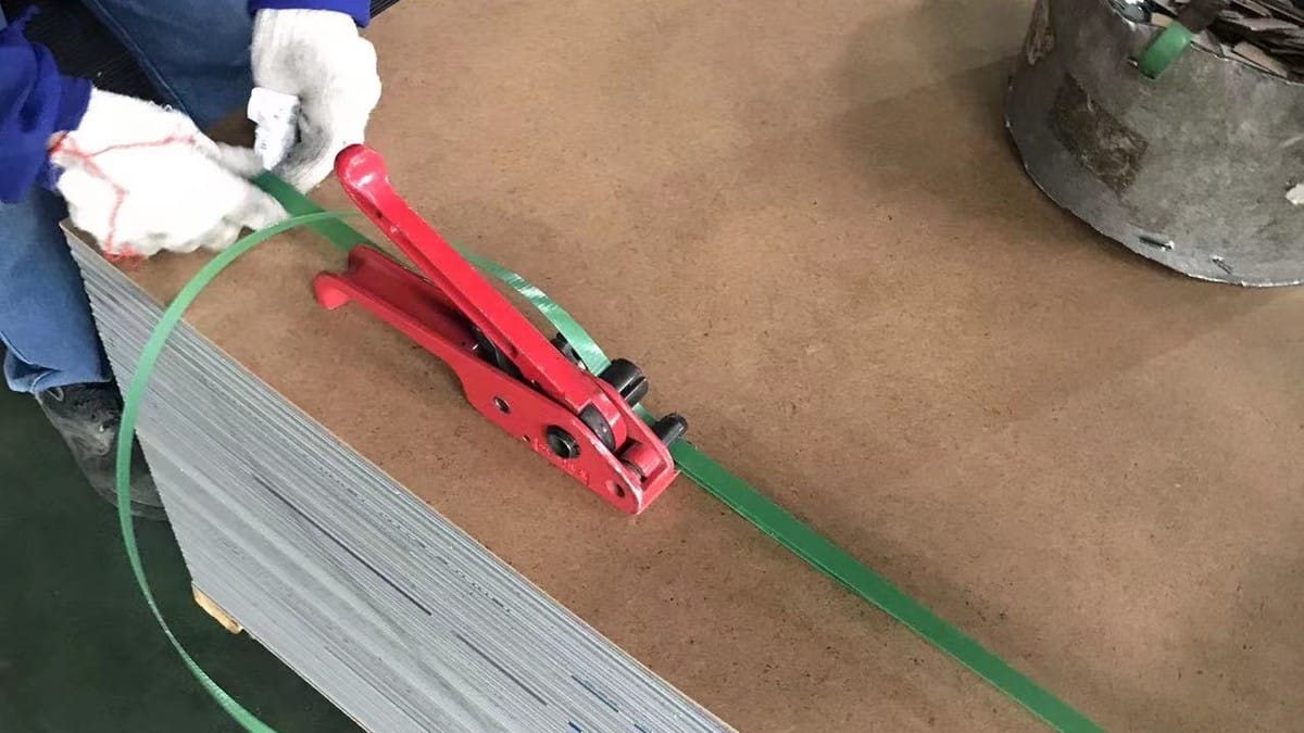 Workers strapping fabricated ACP sheets for protected shipment