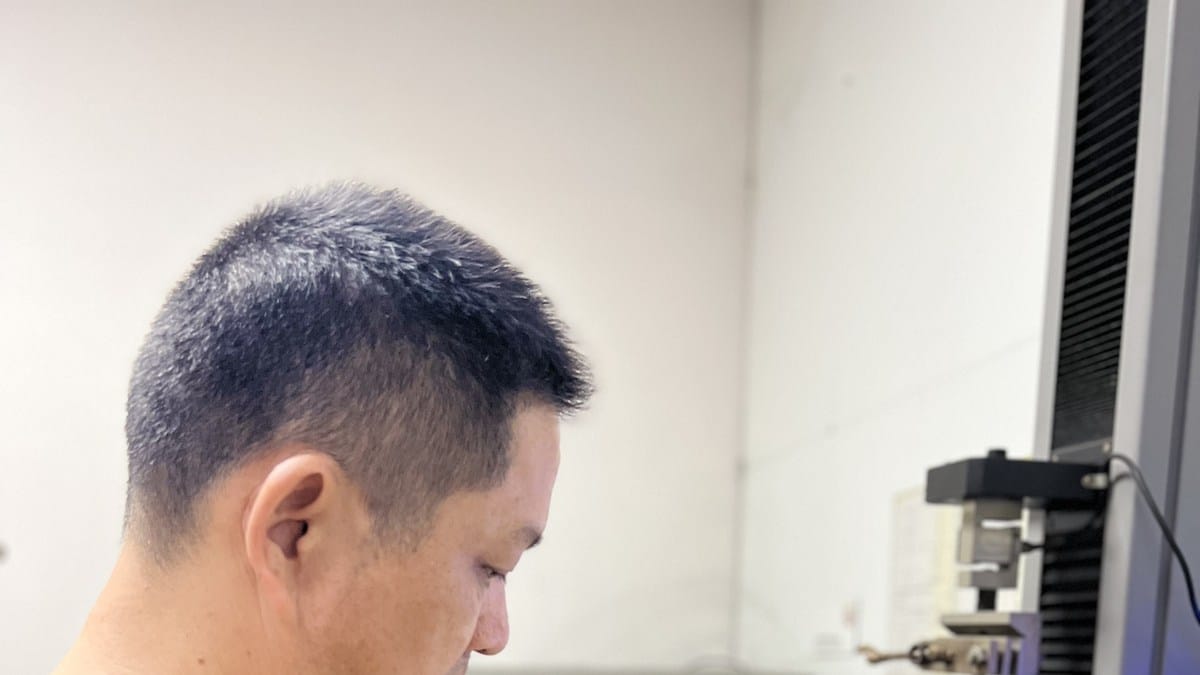 Alcadex technician inspecting and measuring an ACP sample