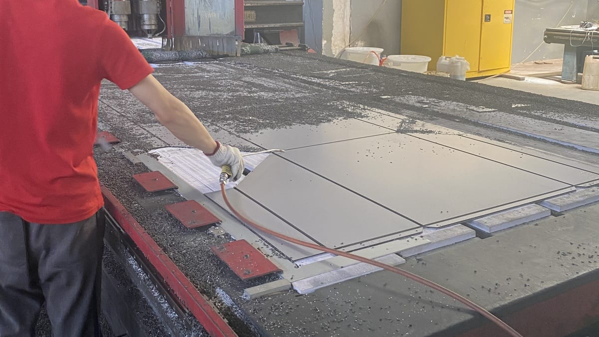 Alcadex worker handling composite panel blanks on a CNC routing table