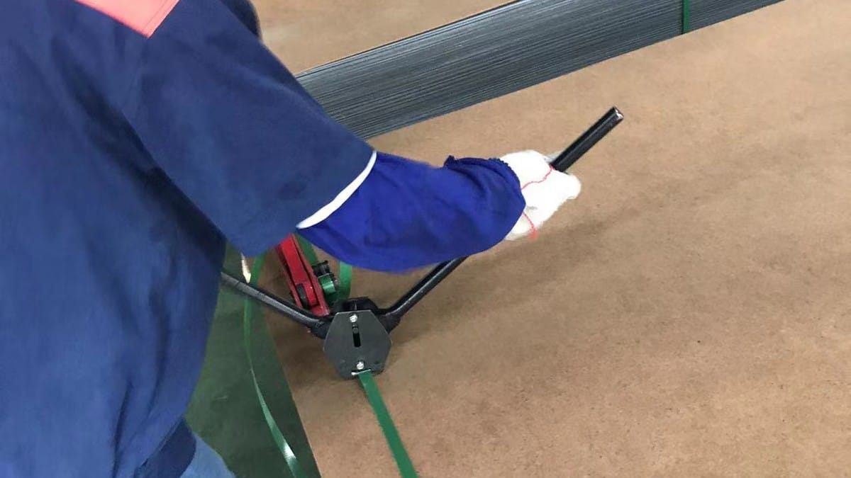 Alcadex worker securing an ACP sheet bundle with protective cover board