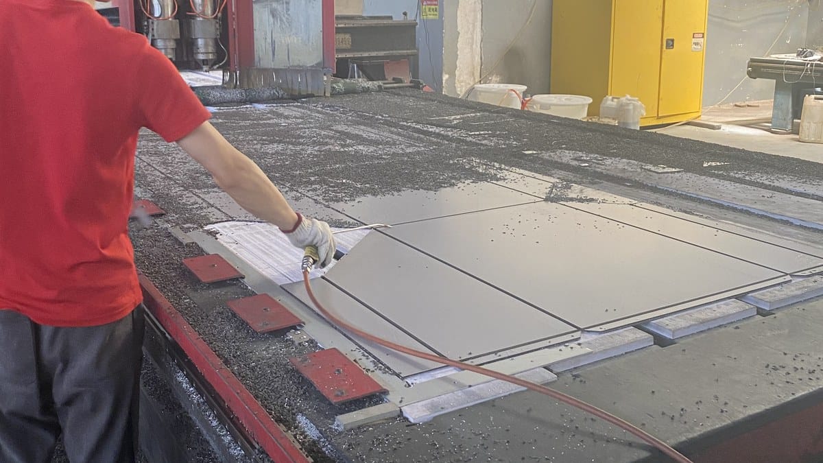 Alcadex worker coordinating fabricated ACP panel parts on a machining table