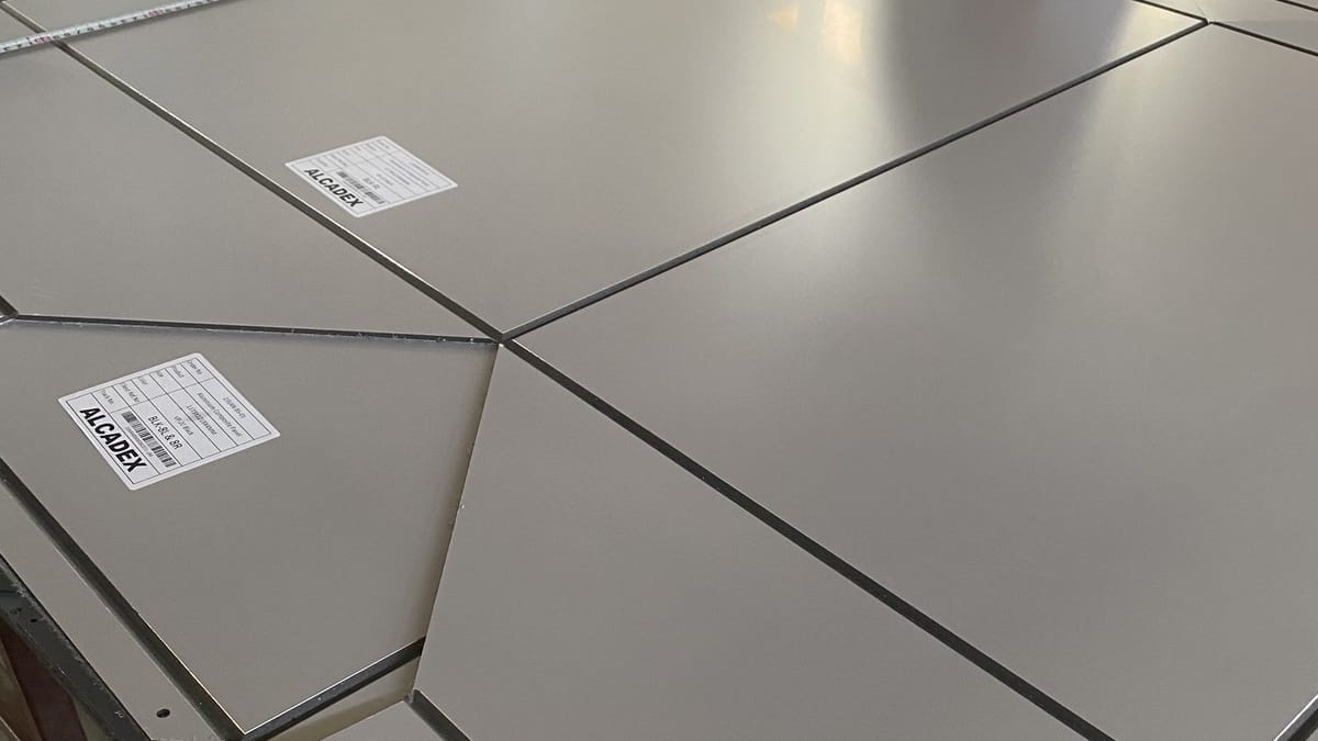 Solid Alcadex composite panels with identification labels arranged on a fabrication table